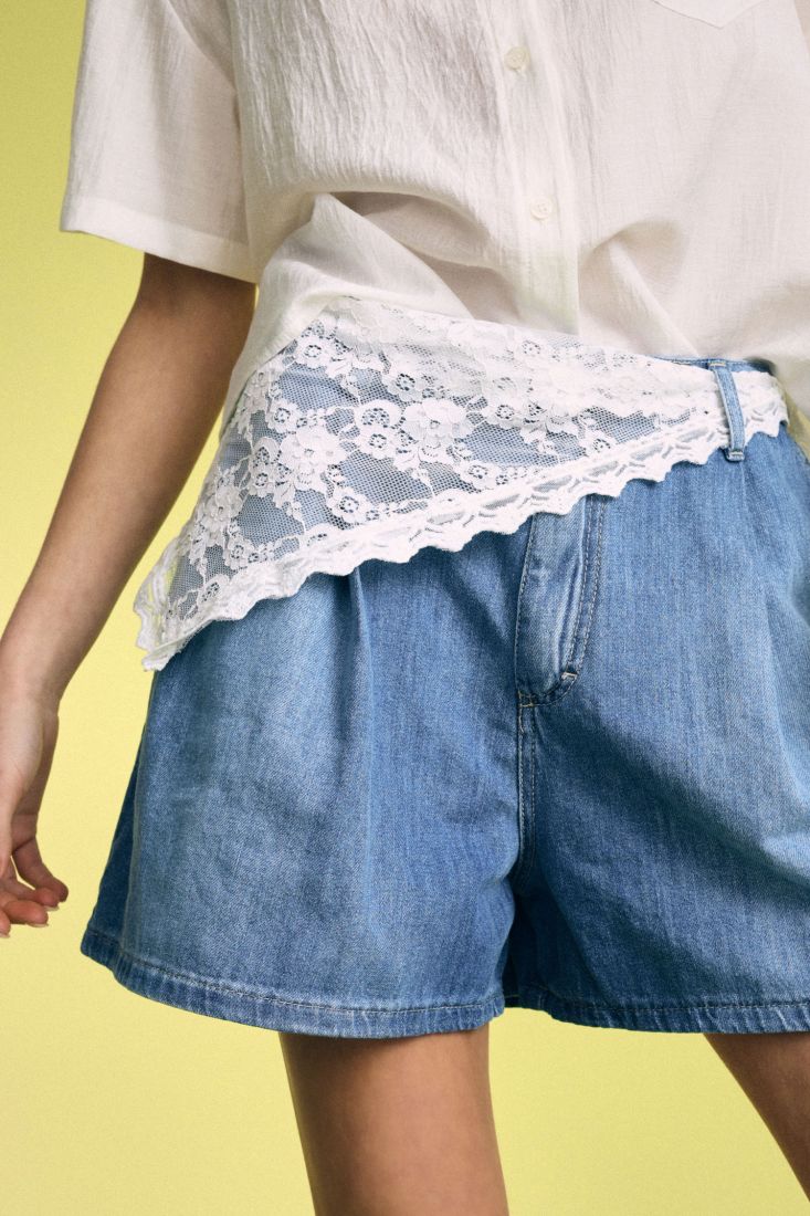 Denim skorts with asymmetric lace accent