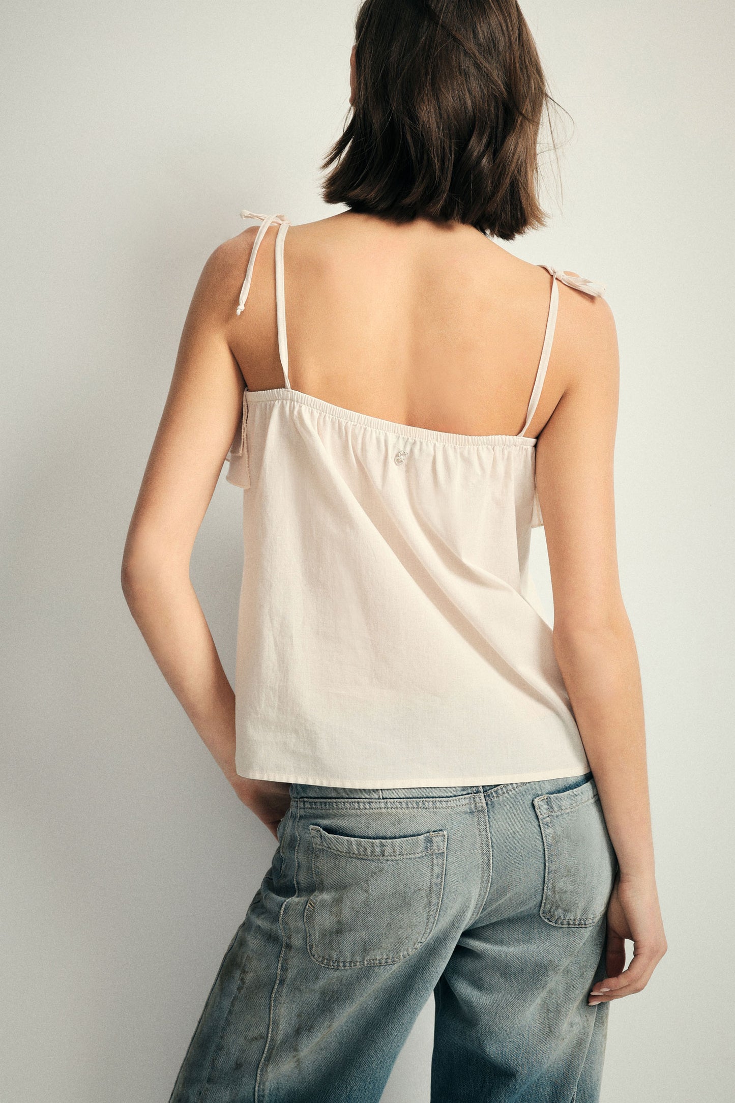 Top with adjustable straps and ruffle detail