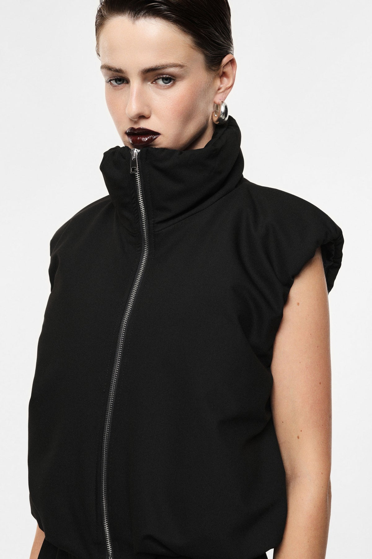 Sleeveless jacket with zip closure and high collar